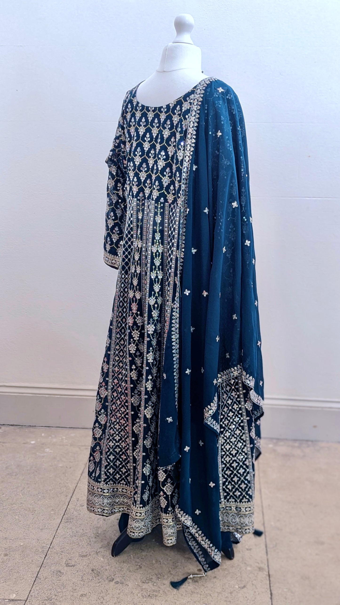 Mannequin in a teal Sherni London palazzo jacket set with front split all over silver embroidery and a dupatta