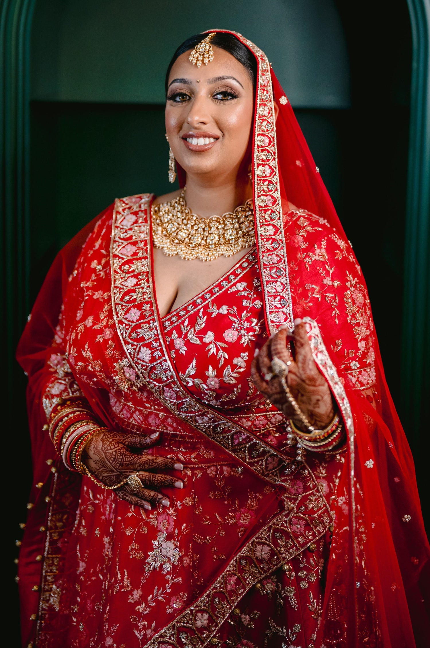 Sherni London real Indian bride in red lehenga and two dupattas, gold embroidery and multicoloured threadwork