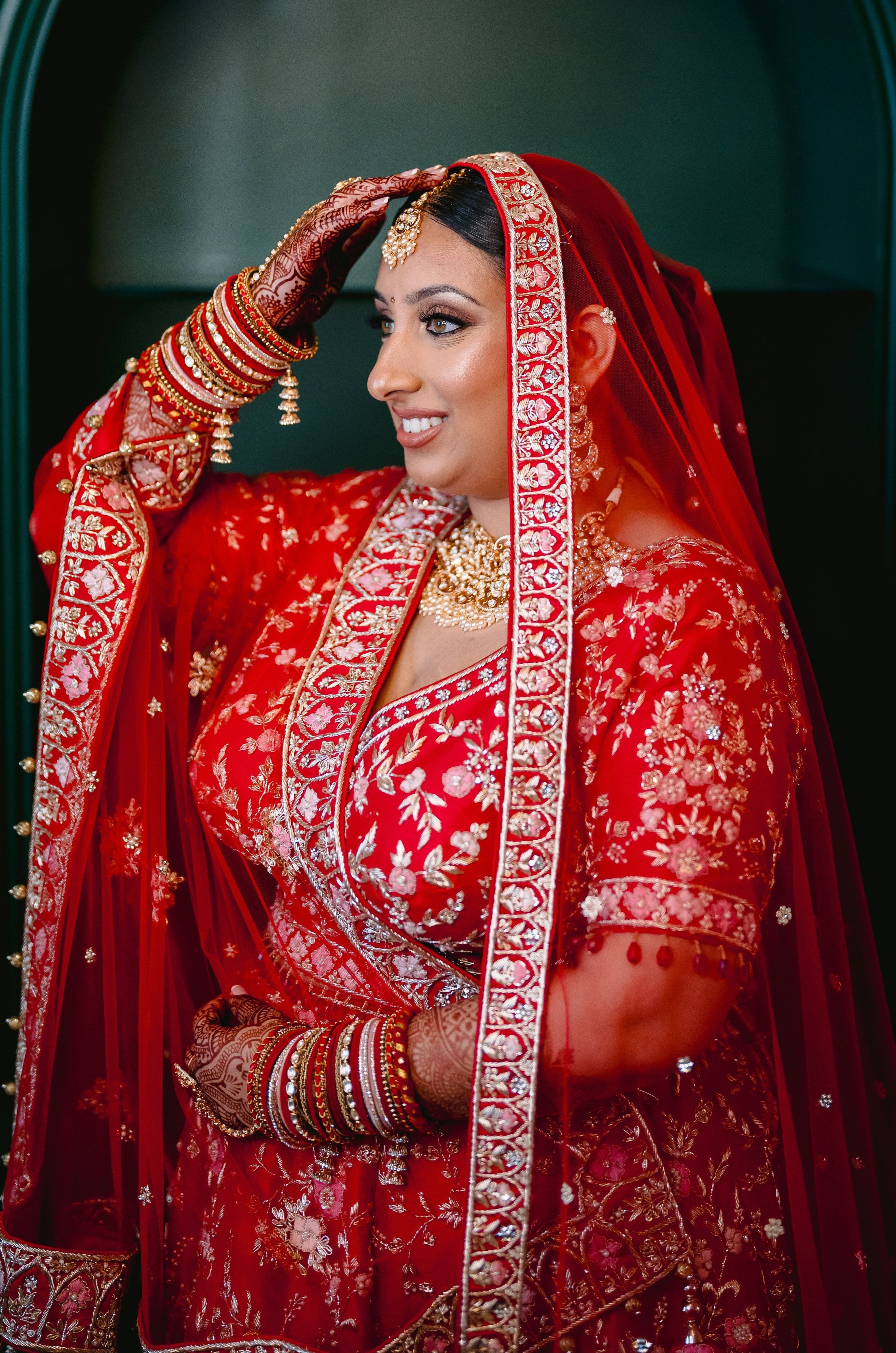 Sherni London real Indian bride in red lehenga and two dupattas, gold embroidery and multicoloured threadwork