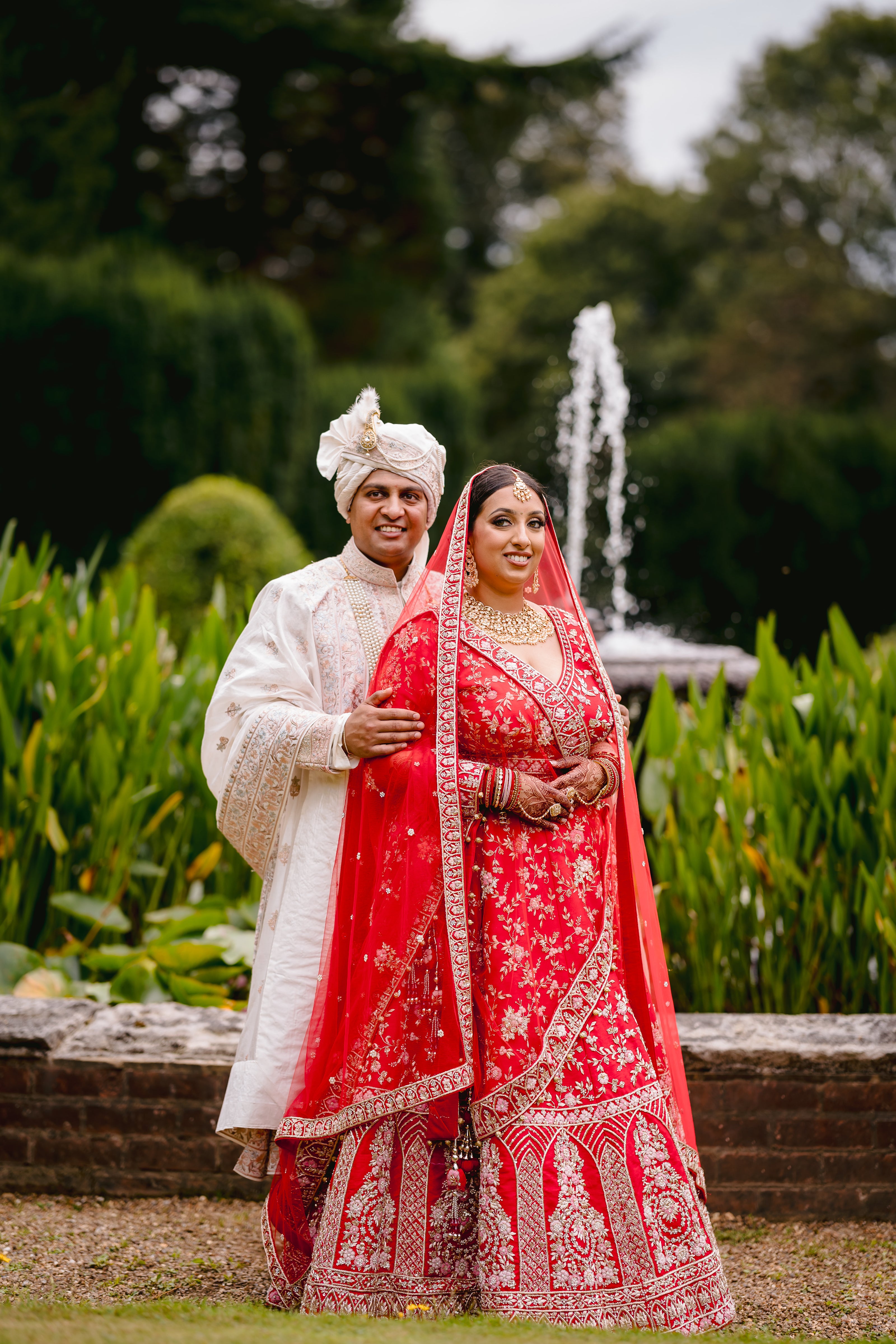 Sherni London Indian bridal lehenga with double dupattas. Bride and groom outdoors on wedding day
