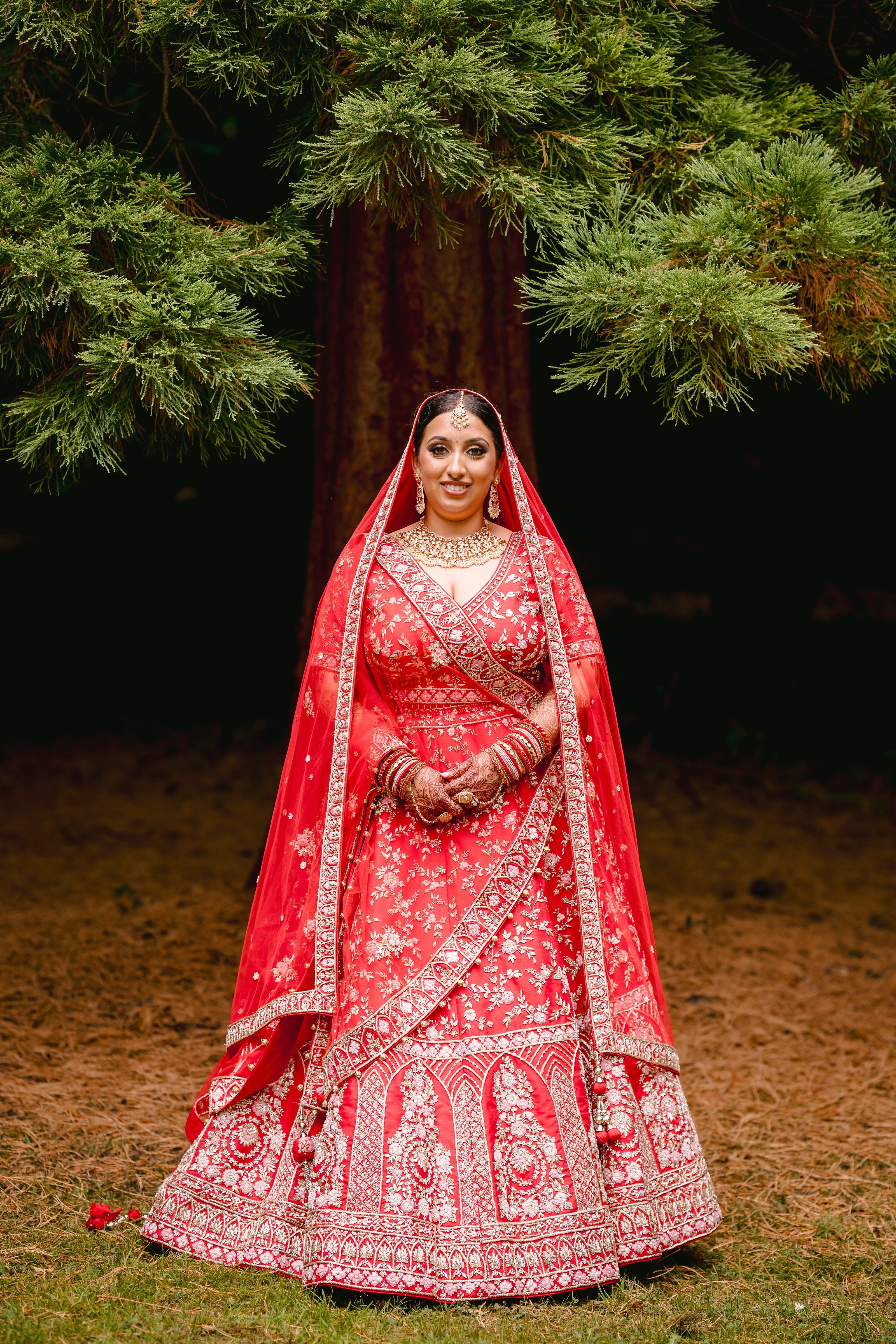 Sherni London real Indian bride in red lehenga and two dupattas, gold embroidery and multicoloured threadwork