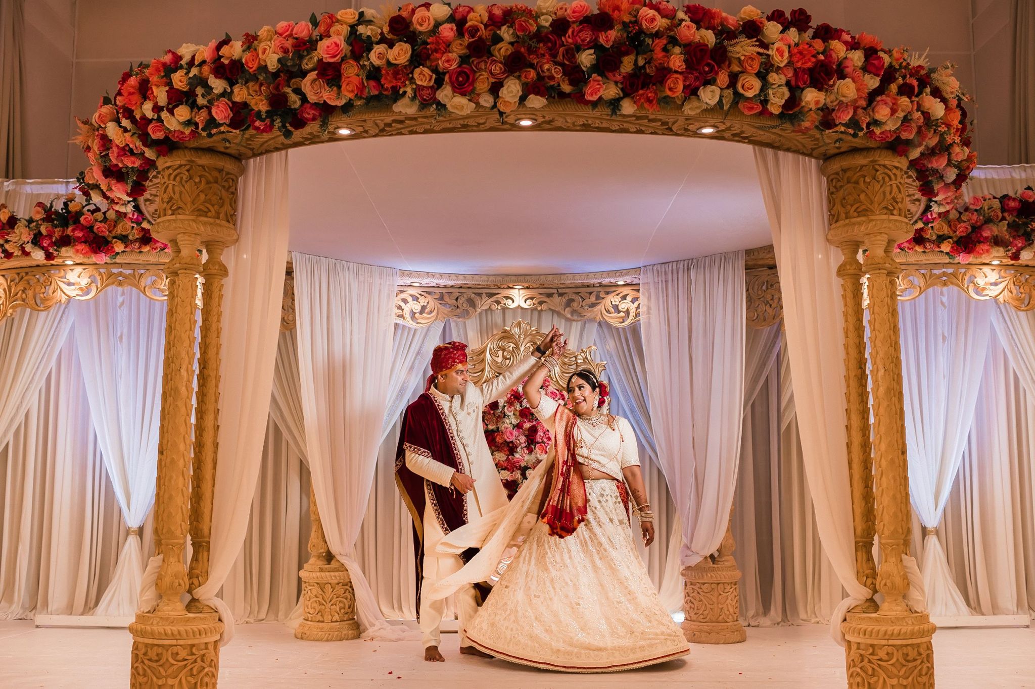 Sherni London bride in cream chikankari lucknowi work Indian lehenga with groom spinning under a mandap at Hindu wedding ceremony