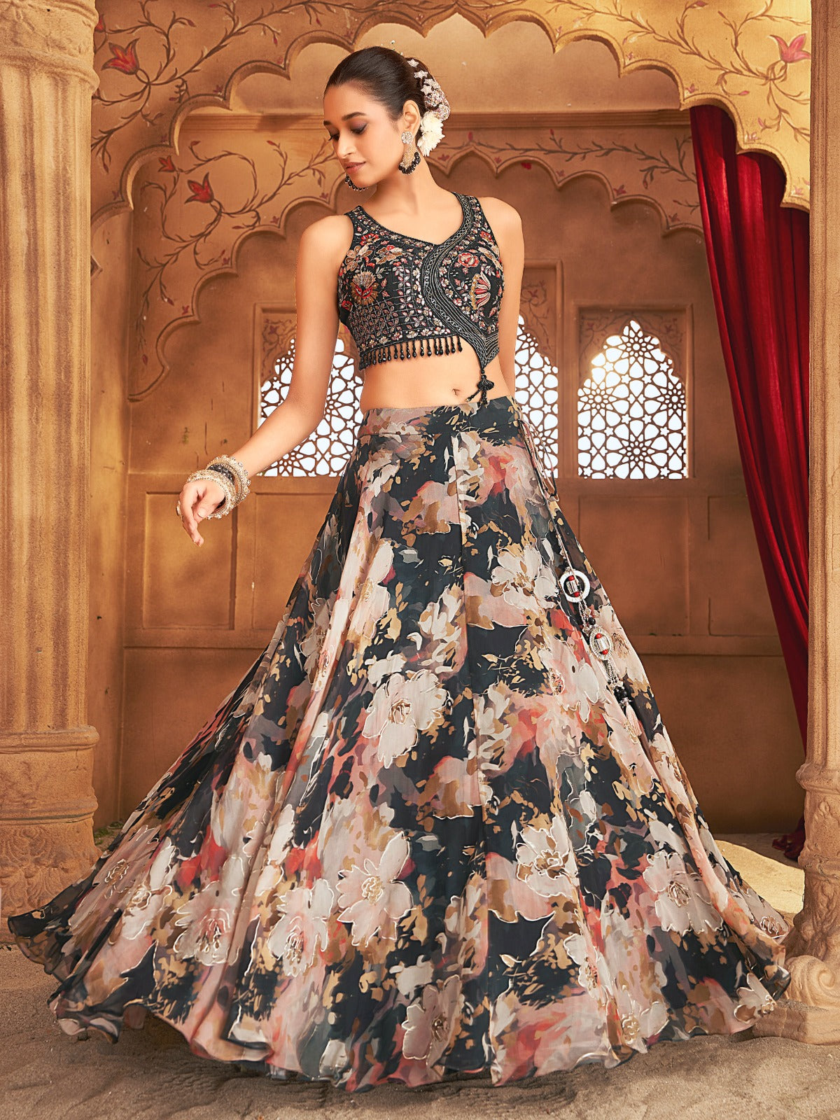 Sherni London floral printed lehenga in black with asymmetric hand embroidered blouse. Lengha is printed with gold highlights overlaid.