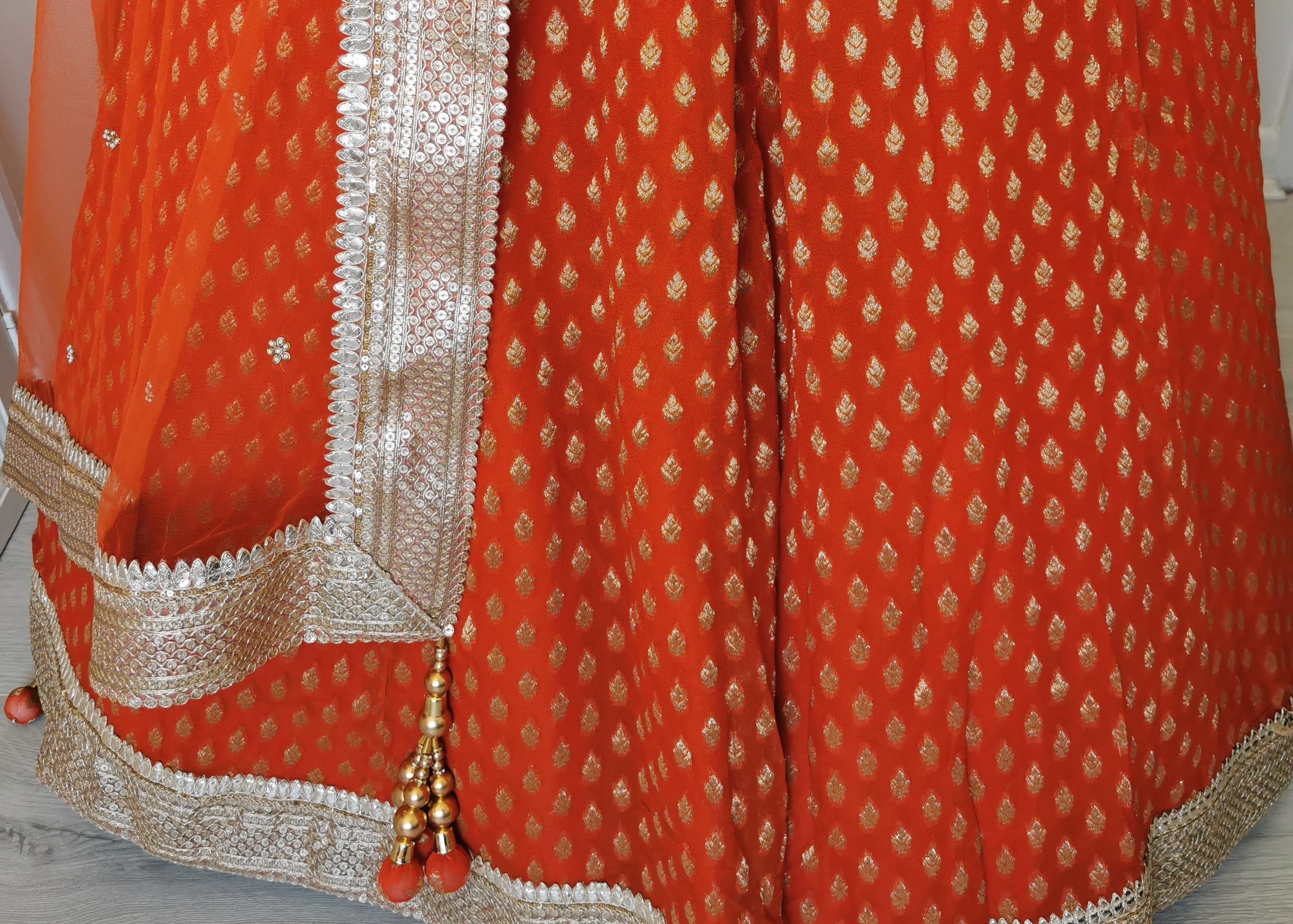 Sherni London orange lehenga choli with gold embroidery and gold borders with orange net dupatta with tassels