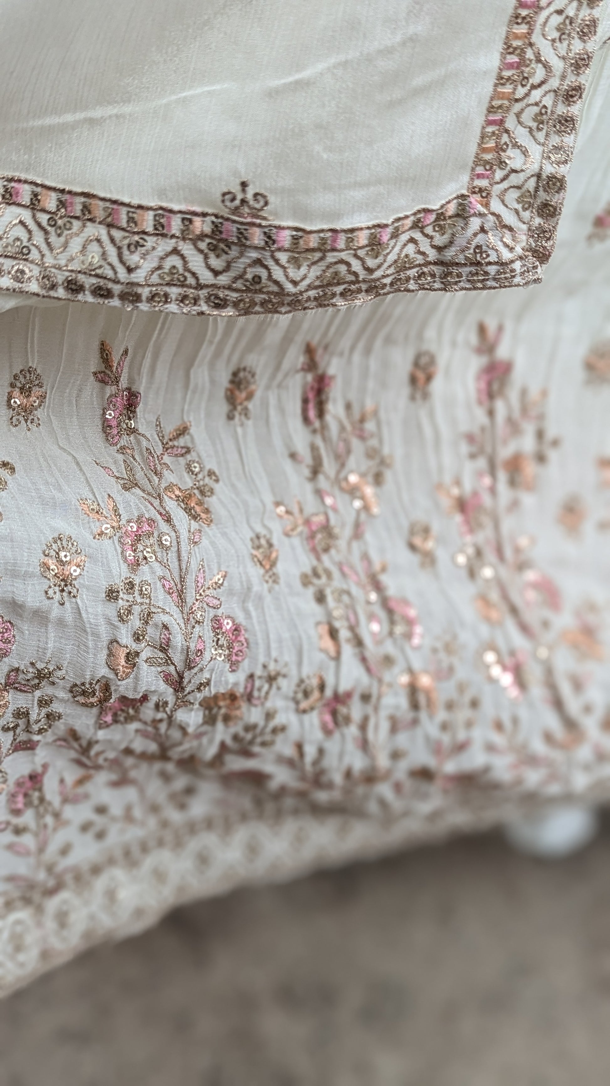 Mannequin wearing a cream jacket sharara suit set with sequins hand embroidery and threadwork long sleeves belt and dupatta