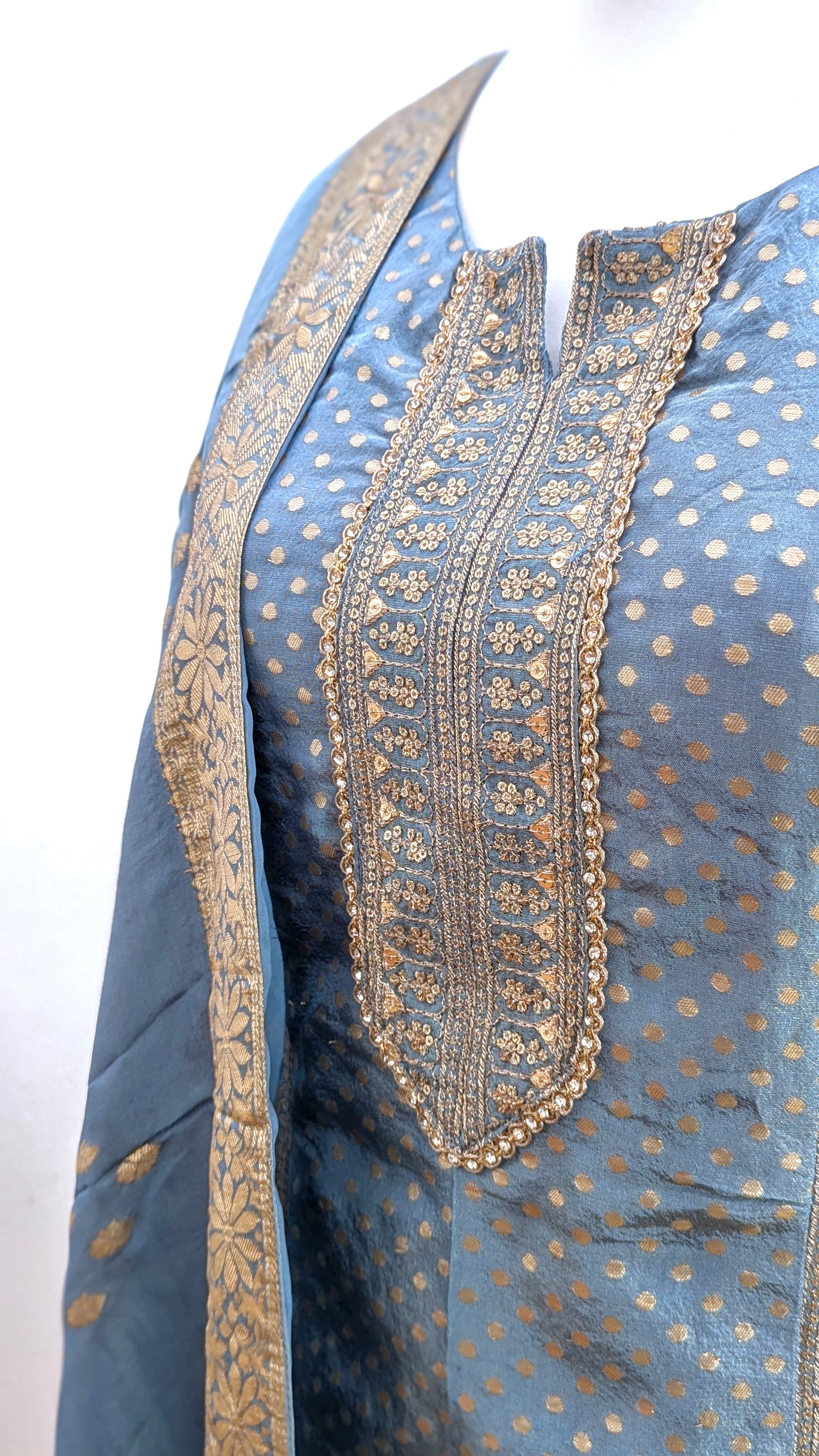 Mannequin with traditional gharara suit in blue grey with gold benarsi print and chevron design all over with sleeves and side tassels