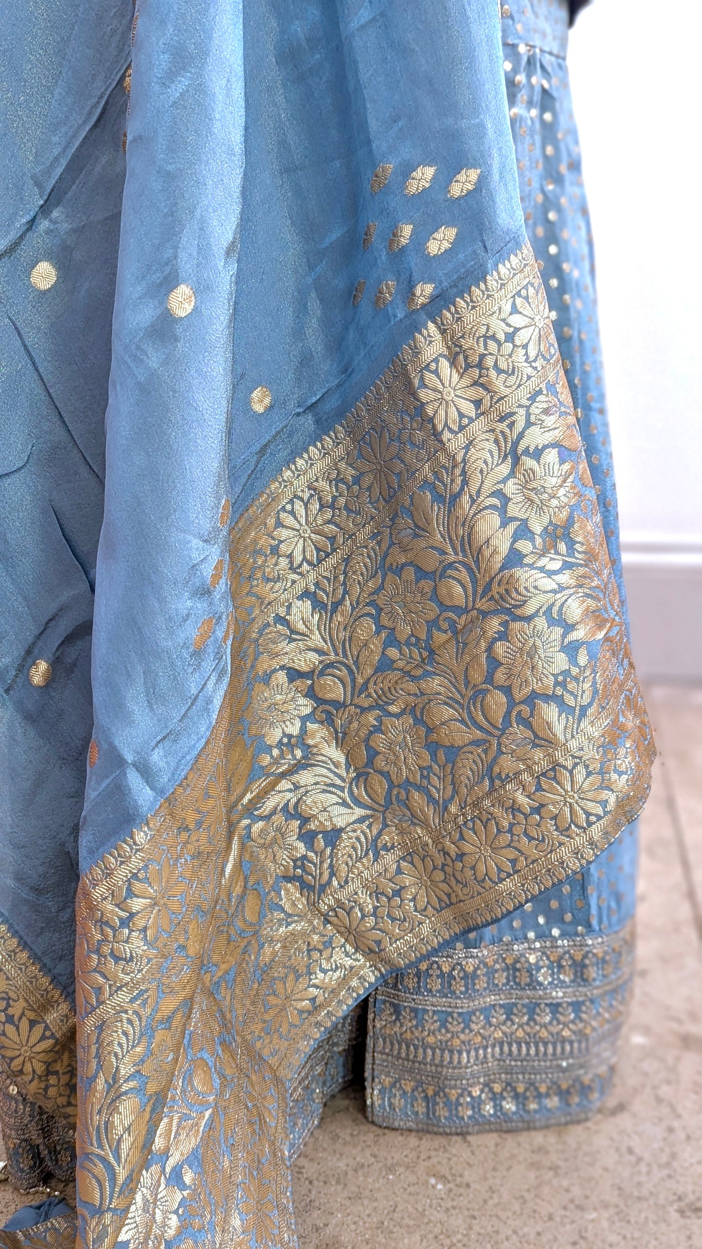 Mannequin with traditional gharara suit in blue grey with gold benarsi print and chevron design all over with sleeves and side tassels
