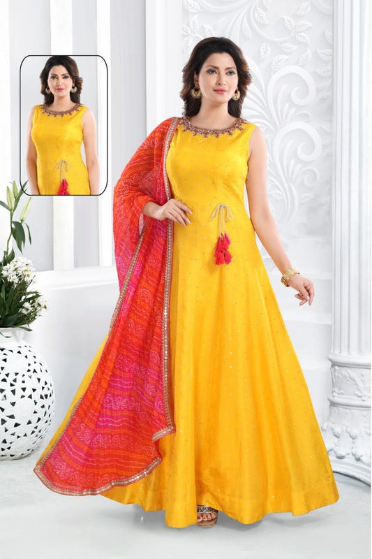 Woman in yellow gown with sequins all over and hand embroidered neckline with pink red and orange bandhani dupatta 